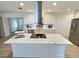 Modern eat-in kitchen with stainless steel appliances, sleek white cabinets and a quartz countertop island at 2869 Thistle N Ct, Palm Harbor, FL 34684