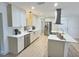 Modern eat-in kitchen with stainless steel appliances, sleek white cabinets, hardwood flooring and a kitchen island at 2869 Thistle N Ct, Palm Harbor, FL 34684