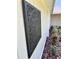 Exterior side view of home featuring an artistic wall decoration and flower beds at 2869 Thistle N Ct, Palm Harbor, FL 34684