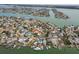 Wide aerial view of a waterfront community with numerous homes, canals and boats in a coastal setting at 301 Boca Ciega Dr, Madeira Beach, FL 33708