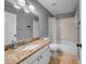 Neutral bathroom featuring granite counters, tan tile floors, tub and shower combination and large mirror at 4010 Lithia Ridge Blvd, Valrico, FL 33596