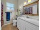 Updated bathroom with a white vanity, marble countertop, gold-framed mirror, and modern fixtures at 4010 Lithia Ridge Blvd, Valrico, FL 33596
