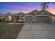 A home with well-lit exterior lighting, a manicured front yard and a spacious driveway leading to a two-car garage at 4010 Lithia Ridge Blvd, Valrico, FL 33596