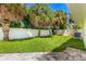 A well-manicured backyard featuring green lawn, tropical trees, and a privacy fence for peaceful outdoor enjoyment at 429 88Th Ave, St Pete Beach, FL 33706