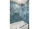 Modern bathroom with blue tile, glass shower, and bathtub at 429 88Th Ave, St Pete Beach, FL 33706