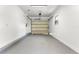 Clean garage with white walls, painted floor, garage door opener and natural light from the window at 429 88Th Ave, St Pete Beach, FL 33706