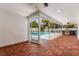 View of the pool and wooden patio with an outdoor kitchen area and sliding glass doors for indoor/outdoor entertaining at 429 88Th Ave, St Pete Beach, FL 33706