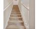 Carpeted staircase with white railing leading to the upper level, enhancing the home's interior at 456 Bahia Beach Blvd, Ruskin, FL 33570