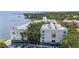 Aerial view of a white condo building featuring lush trees and waterfront access in a desirable location at 4950 Bayshore Blvd # 27, Tampa, FL 33611
