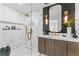 The stylish bathroom has a walk-in glass shower, marble walls, and modern vanity with gold fixtures at 4950 Bayshore Blvd # 27, Tampa, FL 33611