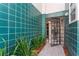 Stylish condo entrance featuring vibrant teal tile, lush landscaping, and an open doorway at 4950 Bayshore Blvd # 27, Tampa, FL 33611