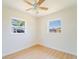 Bright bedroom with two windows, ceiling fan, and light wood-look flooring at 5290 101St Ave, Pinellas Park, FL 33782