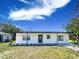 Inviting home boasting a modern exterior, an inviting covered porch, and lush landscaping under a bright blue sky at 5290 101St Ave, Pinellas Park, FL 33782