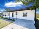 Charming home showcasing a covered entry, freshly painted exterior, manicured lawn, and decorative black trim detail at 5290 101St Ave, Pinellas Park, FL 33782
