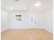 Bright living room with wood look floors, white walls, window, and glass accent front door at 5290 101St Ave, Pinellas Park, FL 33782