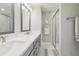 A pristine bathroom featuring a double vanity, framed mirrors, and a glass-enclosed shower at 5351 Bridge St # 15, Tampa, FL 33611