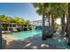 Community pool with pergola shaded lounge, wicker chairs, and lush landscaping perfect for relaxation and socializing at 5351 Bridge St # 15, Tampa, FL 33611