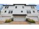 Exterior shot of a three-story townhouse with a white exterior, black shutters, and a brick driveway at 5351 Bridge St # 15, Tampa, FL 33611