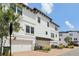 Three-story townhouse with white exterior, black shutters, and a brick driveway at 5351 Bridge St # 15, Tampa, FL 33611
