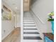 Bright hallway with wood floors, a staircase, and a welcoming beach-themed decor at 5351 Bridge St # 15, Tampa, FL 33611