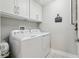 Neat laundry room with washer, dryer, and overhead cabinets at 5351 Bridge St # 15, Tampa, FL 33611