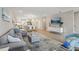 Open-concept living room and kitchen with modern decor, wood flooring, and comfortable gray sofa at 5351 Bridge St # 15, Tampa, FL 33611
