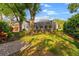 Lush backyard featuring mature trees, brick pathway, and screened-in patio area at 5605 Glencrest Blvd, Tampa, FL 33625