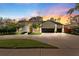 Beautiful home exterior with a three car garage, pristine lawn, and inviting curb appeal at sunset at 5605 Glencrest Blvd, Tampa, FL 33625