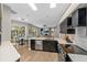 Modern kitchen featuring stainless steel appliances, quartz countertops, and a view to the living area at 5605 Glencrest Blvd, Tampa, FL 33625