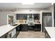 This kitchen features stainless steel appliances, black cabinets and contrasting quartz countertops and backsplash at 5605 Glencrest Blvd, Tampa, FL 33625