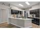 Modern kitchen featuring dark cabinetry, a center island, white countertops, and stainless steel appliances at 5605 Glencrest Blvd, Tampa, FL 33625