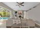 Bright living room with fireplace, ceiling fan, and view of the outdoor pool at 5605 Glencrest Blvd, Tampa, FL 33625