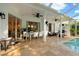 Covered patio with travertine tile, ceiling fans, dining area, and outdoor furniture at 5605 Glencrest Blvd, Tampa, FL 33625