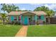 Inviting home with neat landscaping, a vibrant blue door, and a welcoming front garden at 5638 13Th N Ave, St Petersburg, FL 33710