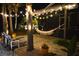 Backyard oasis featuring a hammock, string lights, and palm trees, creating a tranquil and inviting outdoor space at 595 Denburn Ct, Englewood, FL 34223