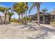 Backyard with tropical landscaping, covered patio, outdoor seating, and a luxurious hammock at 595 Denburn Ct, Englewood, FL 34223