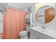Bathroom features a sink and vanity, toilet, and shower with a peach colored curtain at 595 Denburn Ct, Englewood, FL 34223