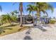 Charming exterior with lush palm trees, a spacious patio, and a cozy hammock for outdoor enjoyment and relaxation at 595 Denburn Ct, Englewood, FL 34223