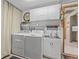 Laundry area with a washing machine, dryer, cabinets, and sink, providing a practical and organized space for laundry tasks at 595 Denburn Ct, Englewood, FL 34223