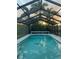 Enclosed pool with a calming ambiance, featuring a clear sky view and a dolphin mosaic on the pool floor at 595 Denburn Ct, Englewood, FL 34223