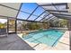 Enclosed pool under a screened enclosure offering a private oasis with a safety railing and a comfortable lounge chair at 595 Denburn Ct, Englewood, FL 34223