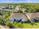Aerial view of the townhome neighborhood, a pond, and verdant surroundings at 602 Cabernet Way, Oldsmar, FL 34677
