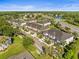 Aerial view of townhomes, lush greenery, and surrounding landscape with a lake nearby at 602 Cabernet Way, Oldsmar, FL 34677