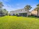 Vast green backyard with palm trees, exterior and screened-in patio for relaxation at 602 Cabernet Way, Oldsmar, FL 34677