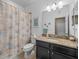 Bright bathroom with a granite countertop vanity and seashell shower curtain at 602 Cabernet Way, Oldsmar, FL 34677