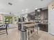 Modern kitchen with dark cabinets, granite countertops, stainless steel appliances, and an eat-in island at 602 Cabernet Way, Oldsmar, FL 34677