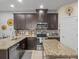 Well-lit kitchen featuring granite countertops, stainless steel appliances, and stylish brown cabinets at 602 Cabernet Way, Oldsmar, FL 34677