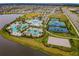 Aerial view of the community center with a resort style pool, tennis court and lake view at 6326 Waves End Pl, Apollo Beach, FL 33572