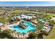 Aerial view of the community center with a resort style pool, tennis court and many palm trees at 6326 Waves End Pl, Apollo Beach, FL 33572