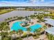 Aerial view of the community center with a resort style pool, water slides and a lake view at 6326 Waves End Pl, Apollo Beach, FL 33572